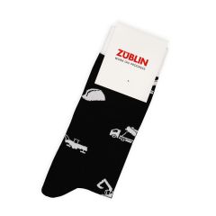A pair of folded black socks with white motifs and a white cardboard tab with the “STRABAG Work in Progress” logo